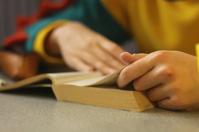 a person sitting at a table with a book